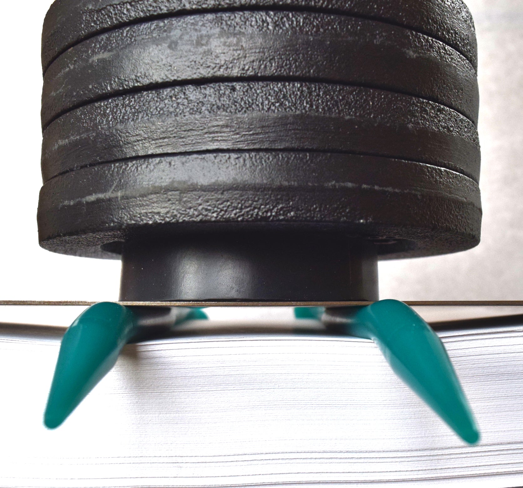 20 lb weight compression test on a teal 00-20 firmness silicone tube under a flat steel plate.
