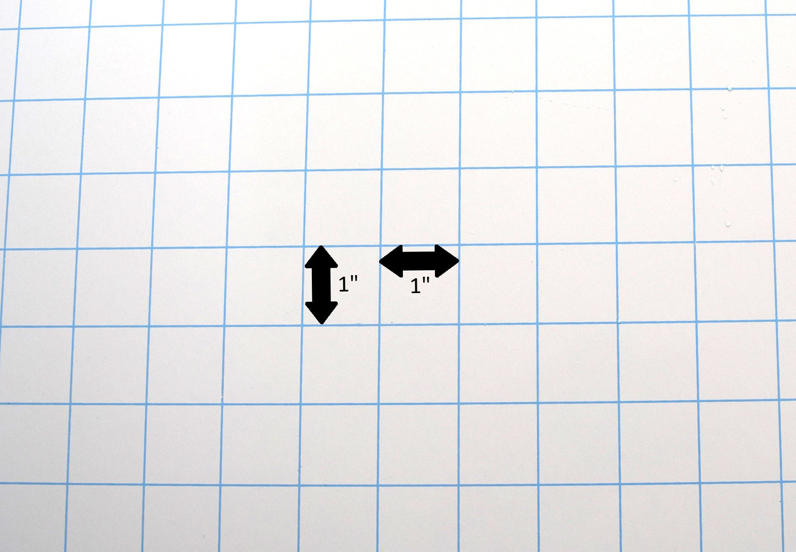 A 1-inch by 1-inch blue grid background used as a reference scale for measuring silicone products, featuring arrows indicating 1-inch dimensions.