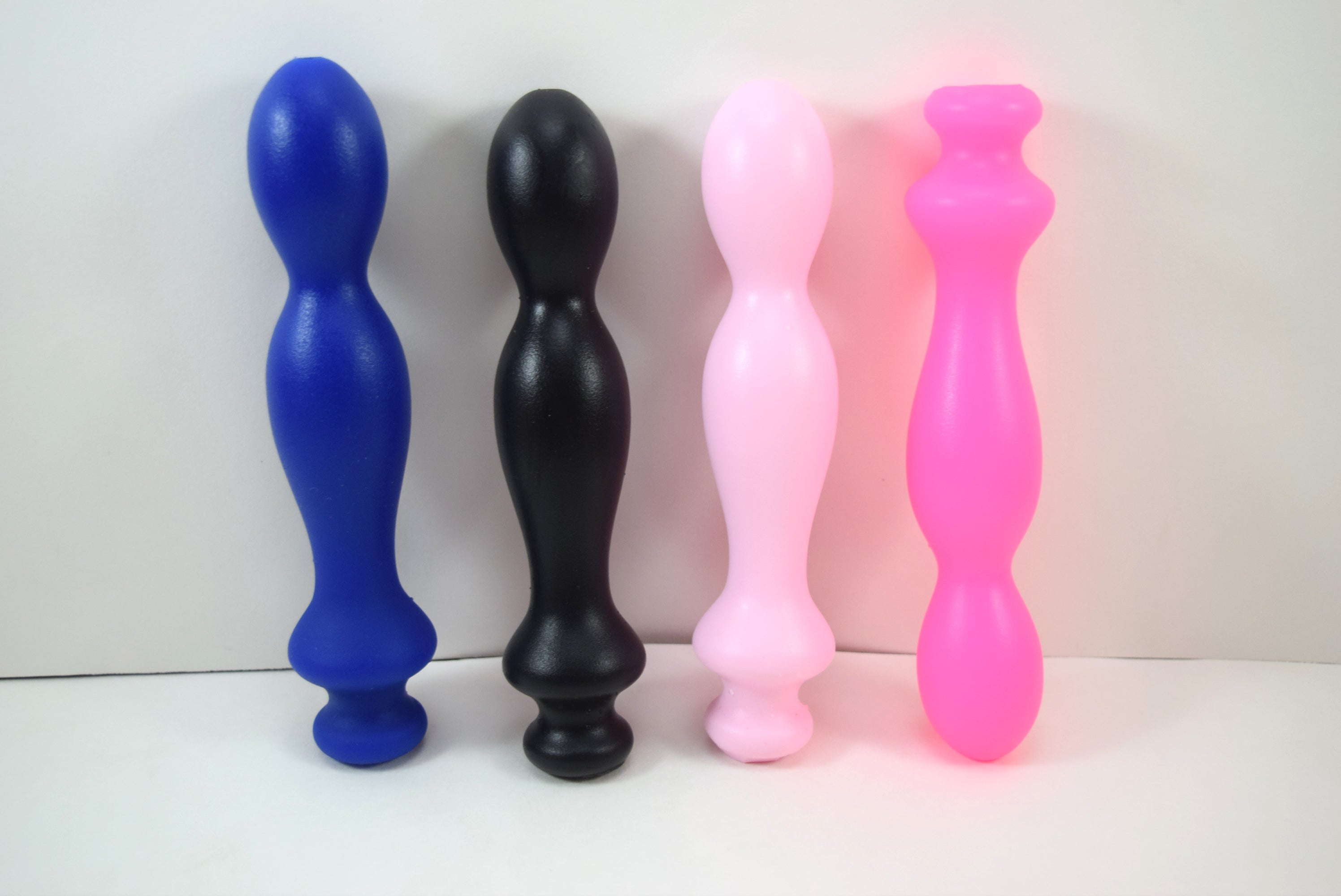 Group shot of Small Ball Tip silicone nozzles in blue, black, pink, and fluorescent pink color variations on a white background