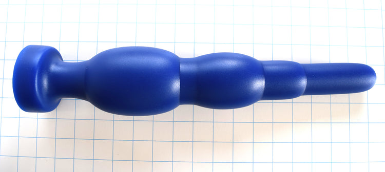 SNC MAX EXT blue silicone retention nozzle featuring an extended nose tip, multi-tiered expansion bulbs, and a safety flange on a grid background