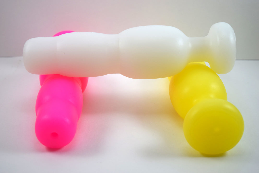 Three SNC MED silicone retention nozzles in white, pink, and yellow, showcasing the multi-stage expansion sections and open bore details