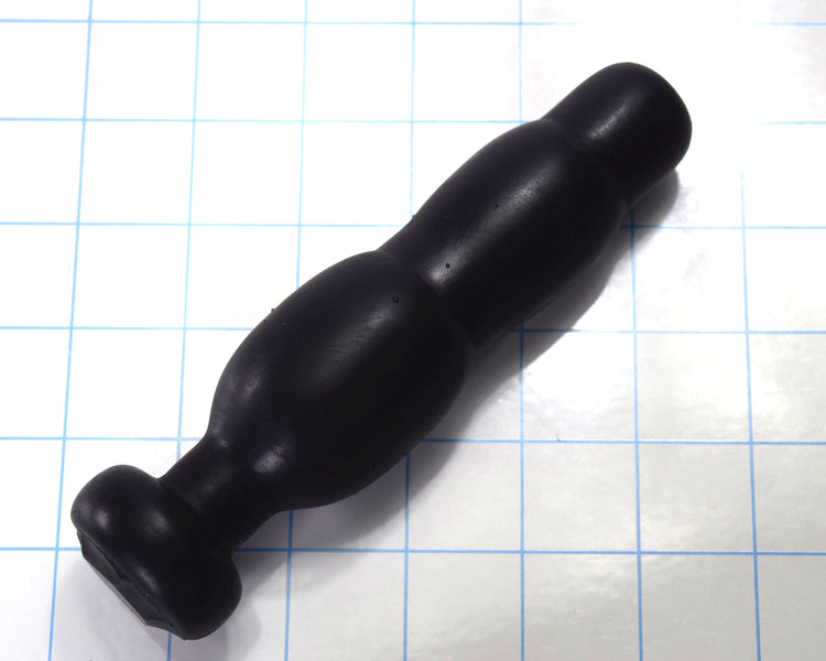 SNC MINI black silicone retention nozzle with a compact triple-bulb design and safety flange resting on a blue grid background
