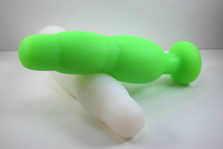 Fluorescent green and white silicone SNC MAX retention nozzles interlocked horizontally on a white background, displaying the 3-inch maximum expansion bulb and safety flange.