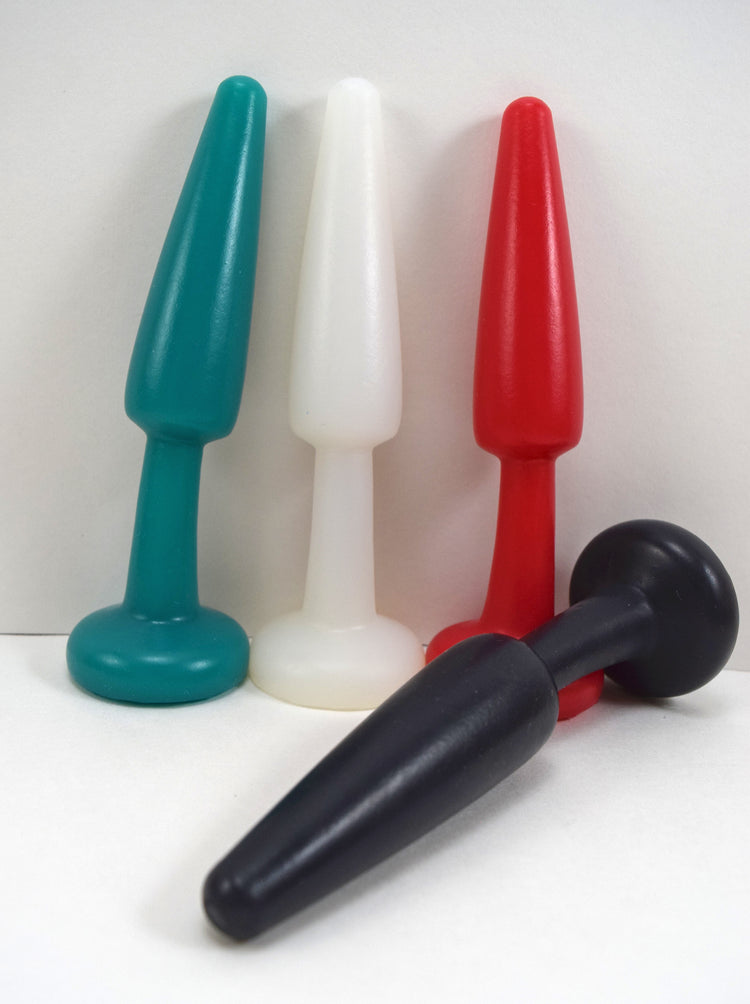 SPD1.1 medium retention style silicone nozzle multi-color lineup featuring dark green, white, red, and black models with 3.5-inch tapered tips, 1.15-inch maximum diameters, and safety retention flanges on a blue grid background.