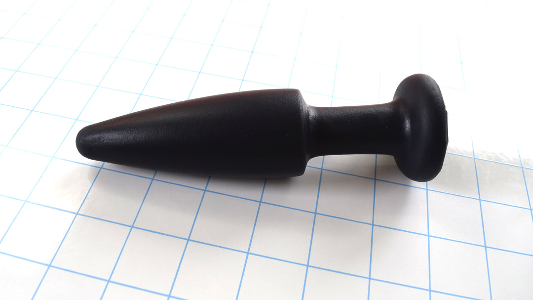 SPD1.5 medium retention style silicone nozzle with 5-inch tapered tip, 1.5-inch maximum diameter, and safety retaining flange on a blue grid background.
