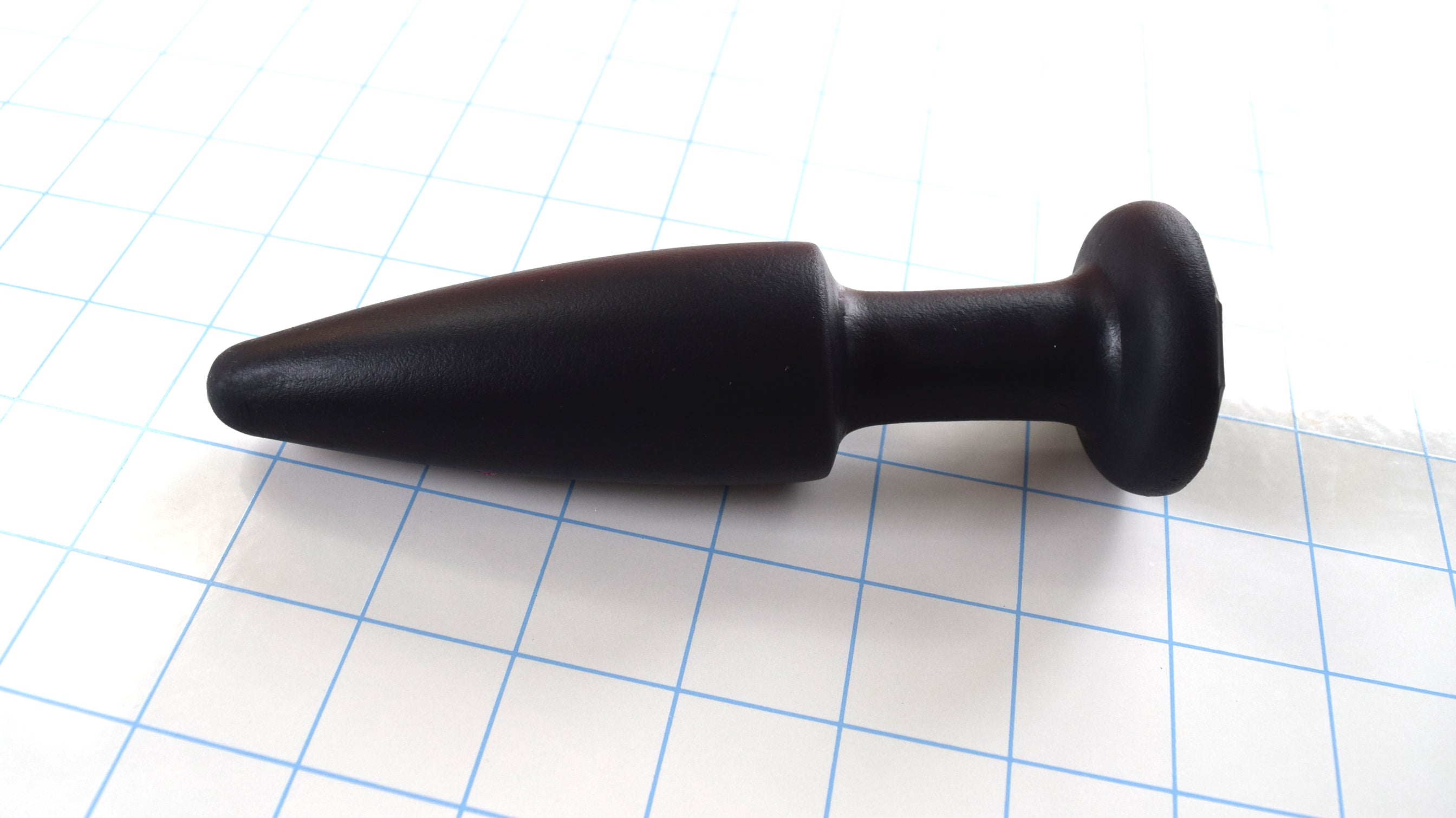 SPD1.5 medium retention style silicone nozzle with 5-inch tapered tip, 1.5-inch maximum diameter, and safety retaining flange on a blue grid background.