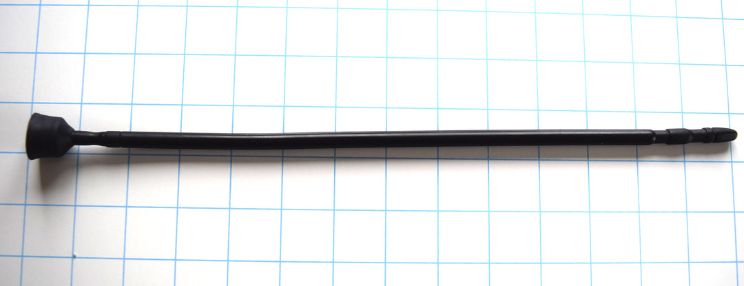 A black 13-inch contoured silicone sound with a multi-faceted tip lying horizontally across a blue grid background.