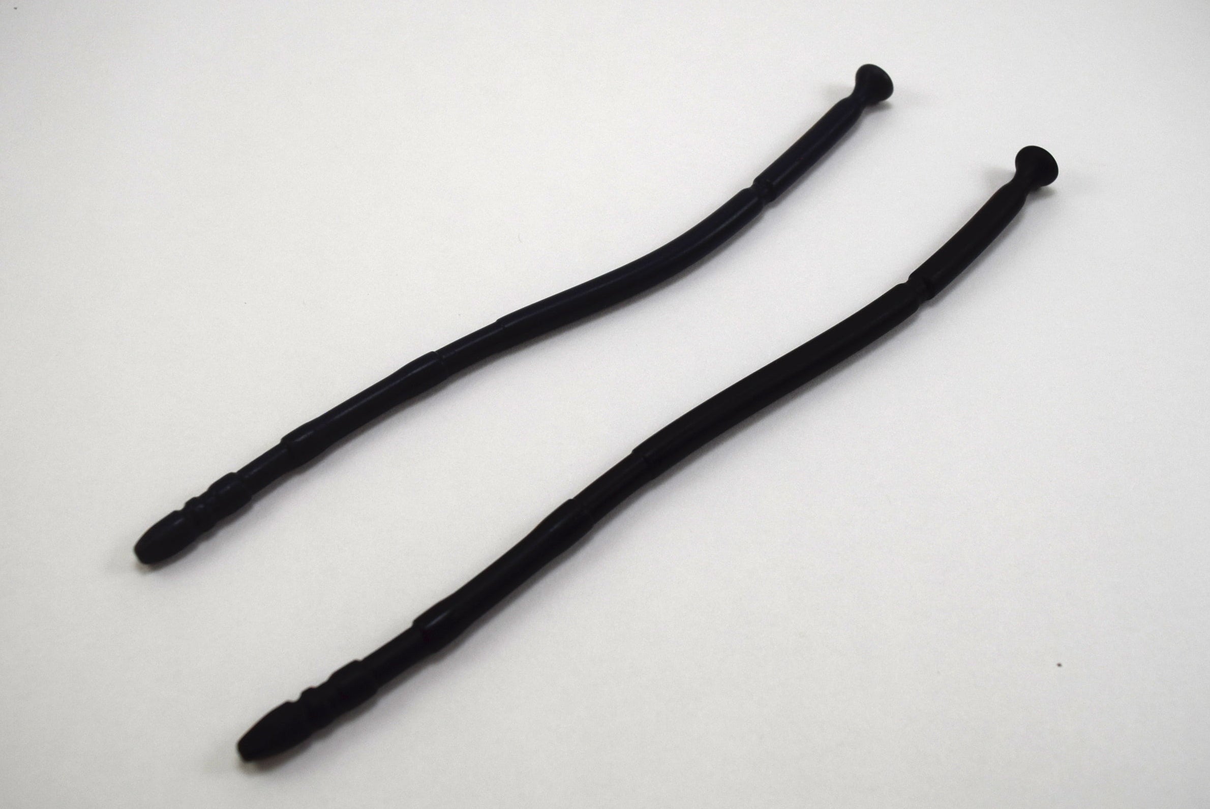 Two black 13-inch contoured silicone sounds with multi-faceted tips laid parallel on a plain white background.