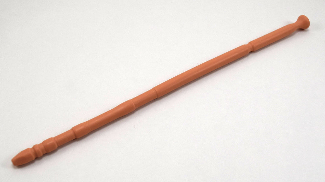 A tan flesh-tone 13-inch contoured silicone sound with a multi-faceted tip lying diagonally on a white background.