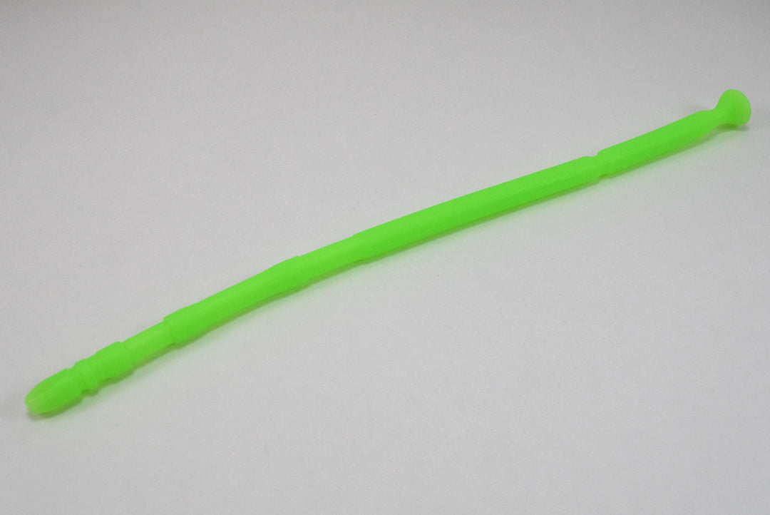 A fluorescent green 13-inch contoured silicone sound with a multi-faceted tip lying diagonally on a plain white surface.