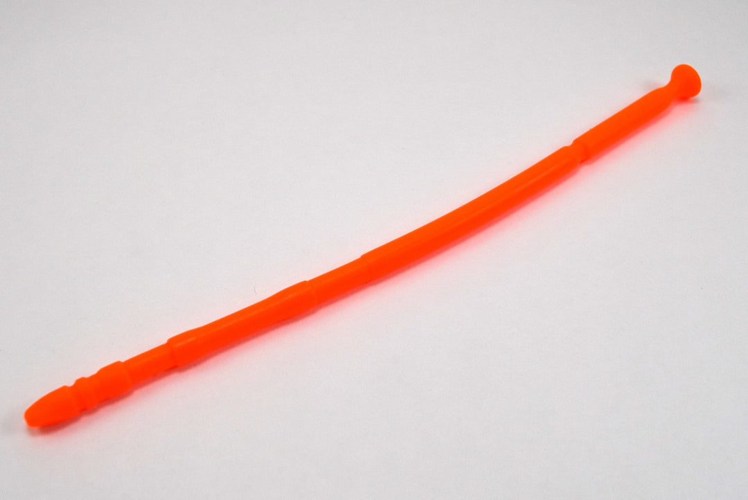 A fluorescent orange 13-inch contoured silicone sound with a multi-faceted tip lying diagonally on a plain white surface.