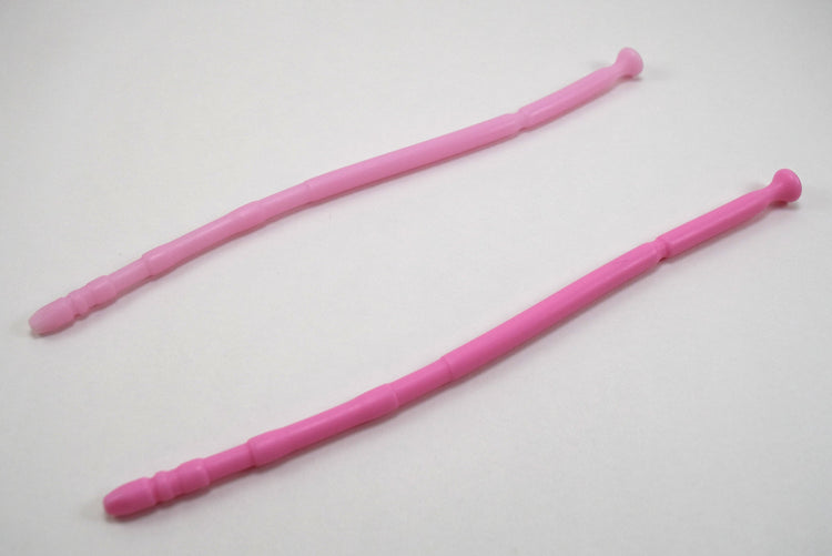 Two light pink 13-inch contoured silicone sounds with multi-faceted tips laid parallel on a plain white surface.