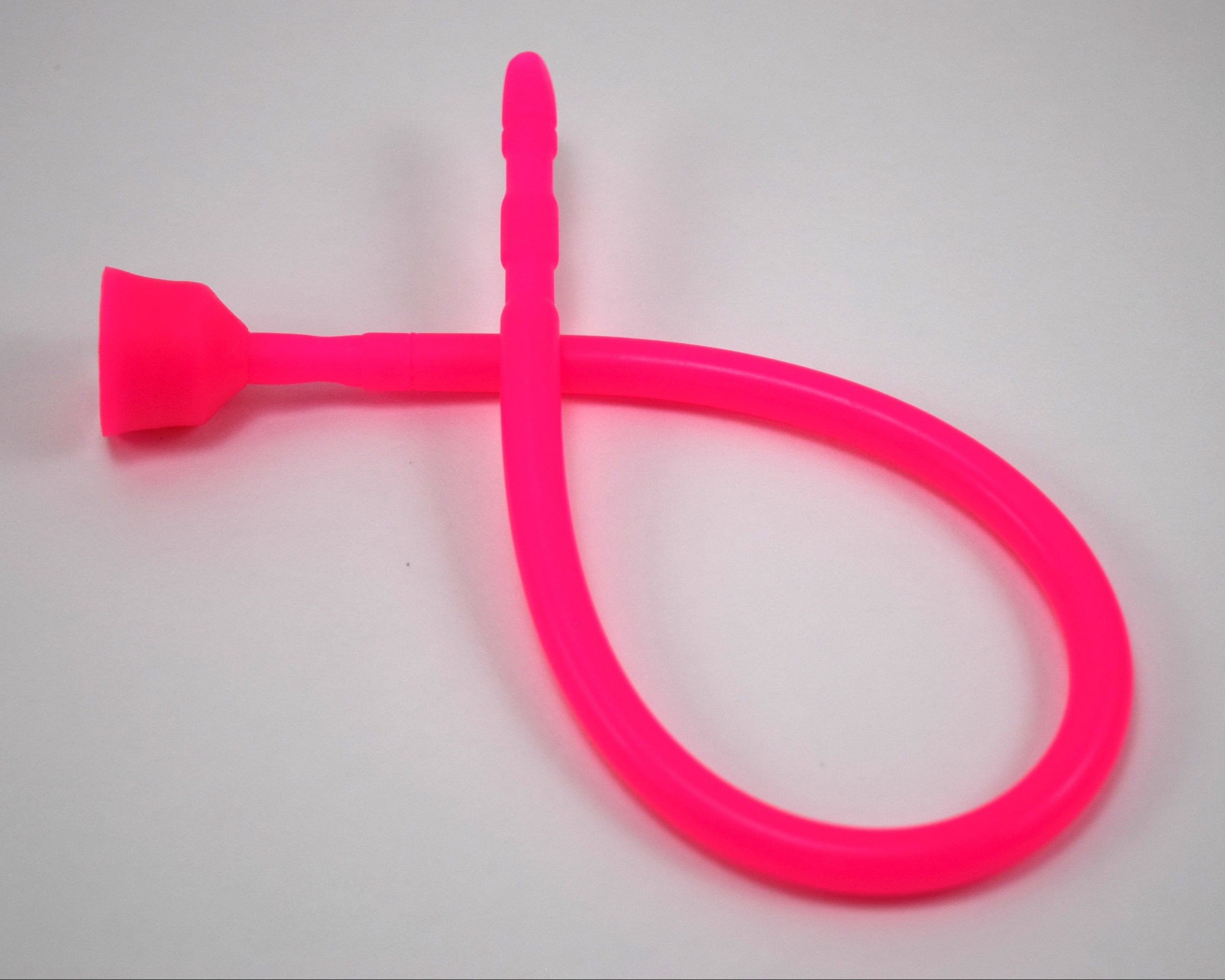 A bright pink 13-inch contoured silicone sound looped into a ribbon shape against a solid white background.