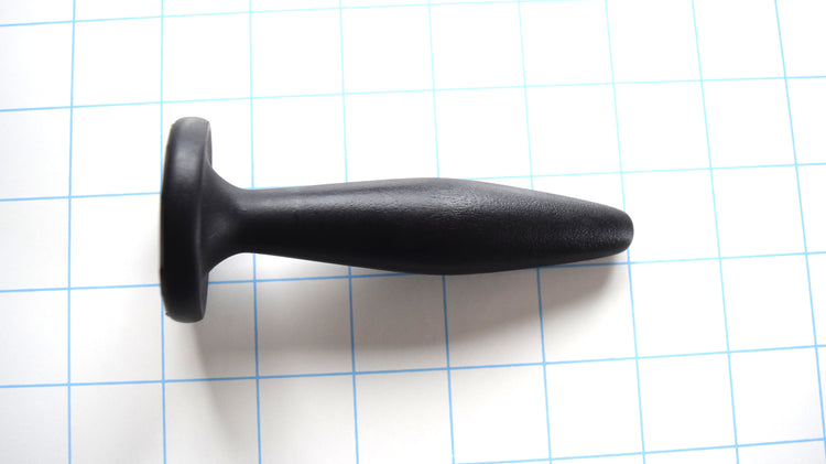 SSND-Diamond 15-23 black silicone urethral plug on grid background showing tapered tip, 23mm diamond expansion, 15mm valley, and flared base.