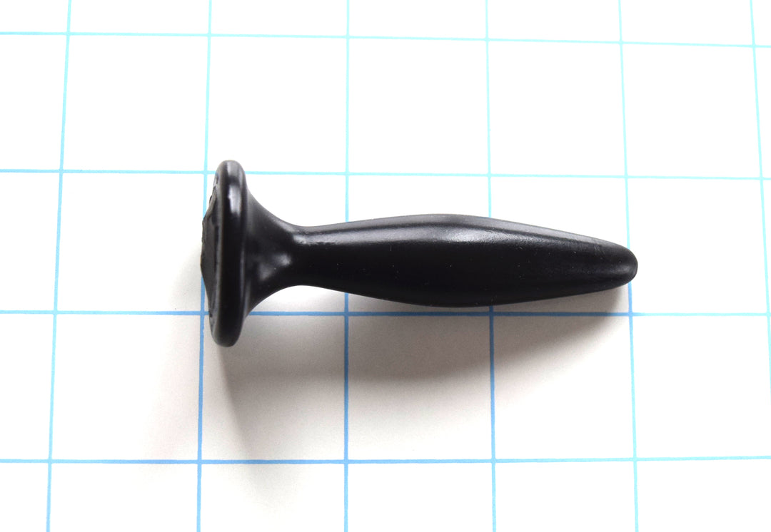 SSND-Diamond Tip 7-16mm short black silicone urethral sound plug resting horizontally on a grid background, highlighting its 7mm entry tip, smooth 16mm central expansion peak, 9.5mm retaining valley, and wide safety flange.