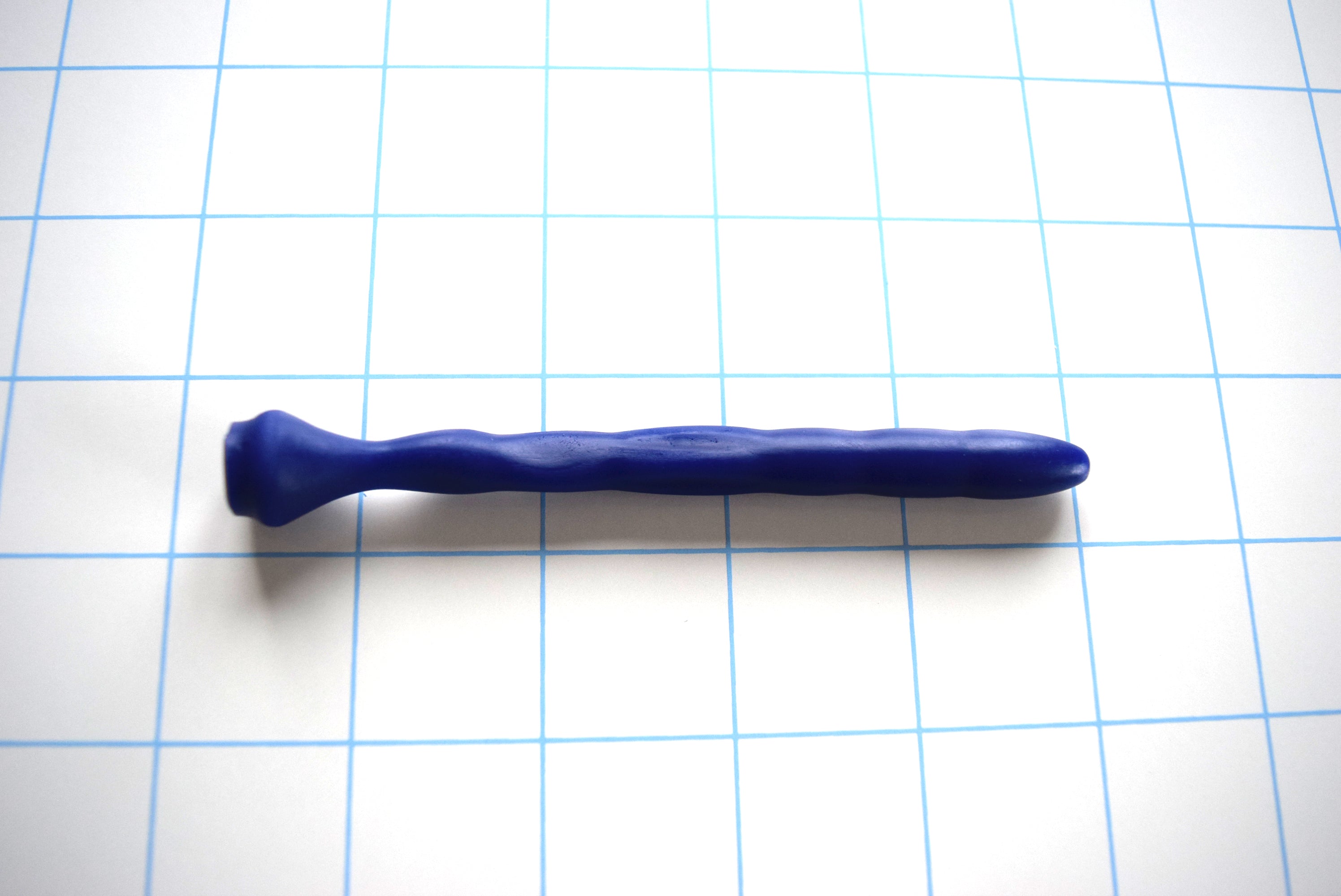 SSND-Dimpled short flexible silicone urethral sound shown in blue on a grid background, highlighting its 5mm rounded tip, 9.25mm dimpled textured shaft, and a narrow 4.75mm flattened billow section leading to a 14.5mm safety base flange.