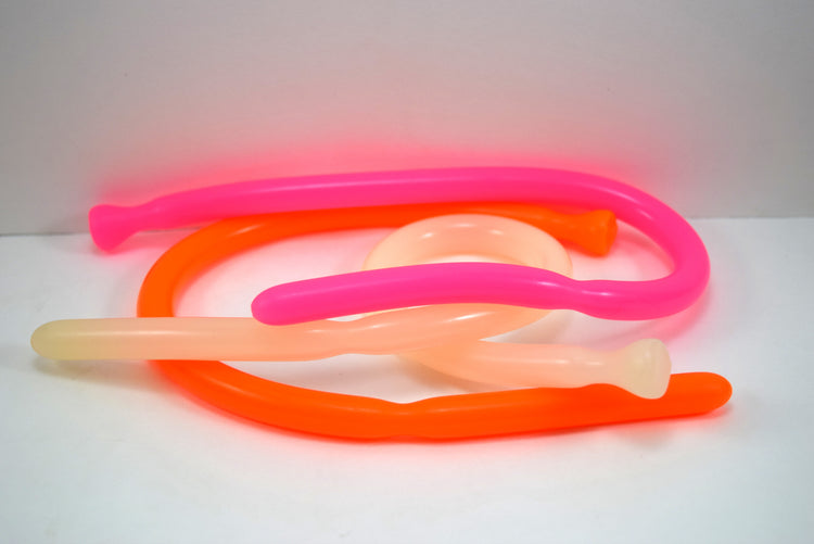 SSND-DS 9-12 flexible silicone sounds coiled together on a white background, pictured in bright pink, neon orange, and translucent clear.