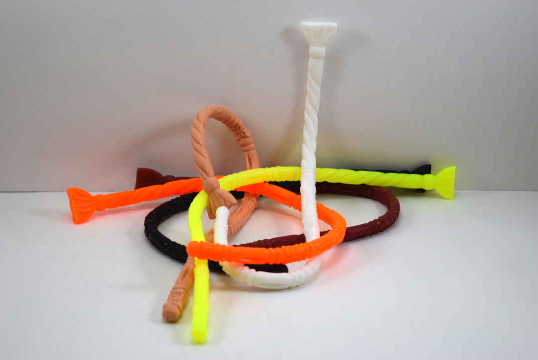 A pile of flexible SSND-FLORENTINE14 textured silicone sounds in multiple vibrant colors including white, neon orange, bright yellow, peach, black, and maroon.