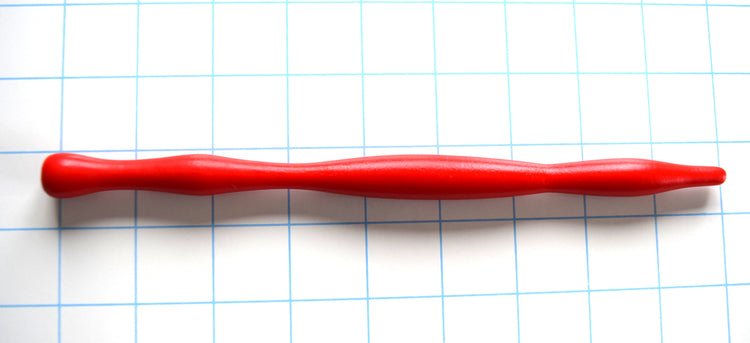 Red silicone sensory barrel sound with smooth contoured swells and a rounded ball flange on a grid background.