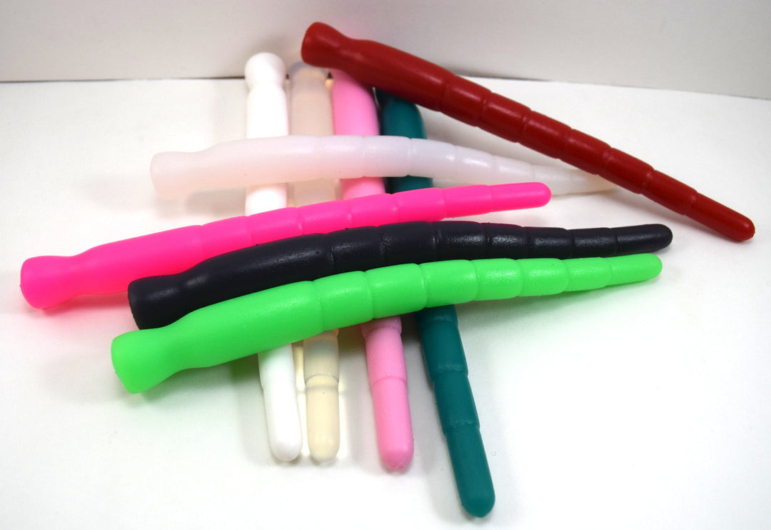 A pile of multi-dimensional silicone stretching sounds in green, pink, black, red, and white on a plain background.