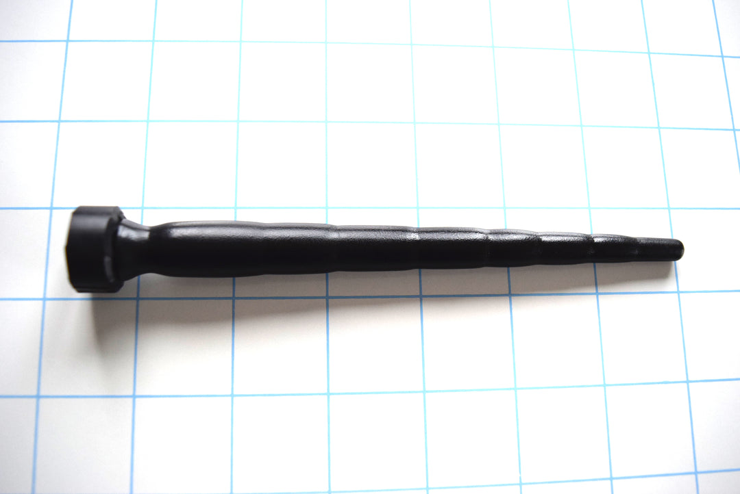 SSND-MD 6-14 advanced black silicone urethral sound shown horizontally on a white background with 1"x1" blue grid squares. Highlighting its 8 graduated segments scaling from 6.85mm to 14mm, 5.75-inch insertable length, and deep retention valley ahead of the safety base.