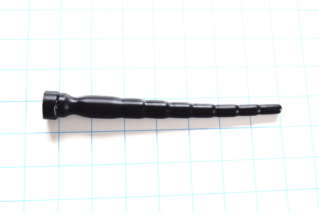 SSND-MD 8-16 advanced black silicone urethral sound shown horizontally on a white background with 1"x1" blue grid squares . Highlighting its 8 graduated segments scaling from 8mm to 16mm, 6-inch insertable length, and deep retention valley ahead of the safety base.