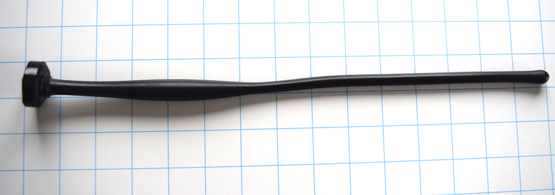 SSND-MGCWAND14 advanced black silicone urethral sound shown horizontally on a white background with 1"x1" blue grid squares from Screenshot 2026-07-02 161837.jpg, showcasing its 10.5mm rounded entry tip, 8-inch long slender tracking shaft, 15mm oval expansion body, and flat-backed safety flange.
