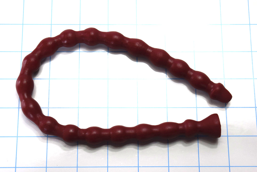 A dark red silicone multi-ribbed sound curves looped across a blue grid background showing distinct nodes and a flared base.