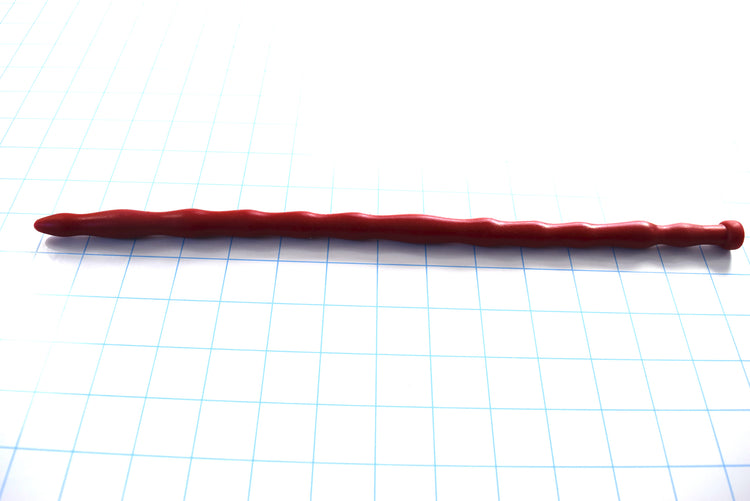 SSND-MRB 11.5-14.5 silicone sounding rod in dark brick red shown laid out horizontally on a white background with 1-inch blue grid lines, featuring 12 ribbed segments up to 14.5mm, a 10mm retention valley, and a flared safety base.