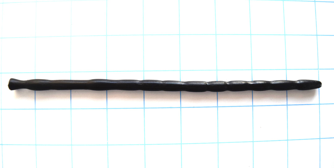 SSND-MRB 7-8mm multi-ribbed black silicone urethral sound shown horizontally on a grid background, highlighting its 10 unique texturing ribs, 9.5mm final retaining egg, 5.5mm deep retention valley groove, and flared safety base flange.