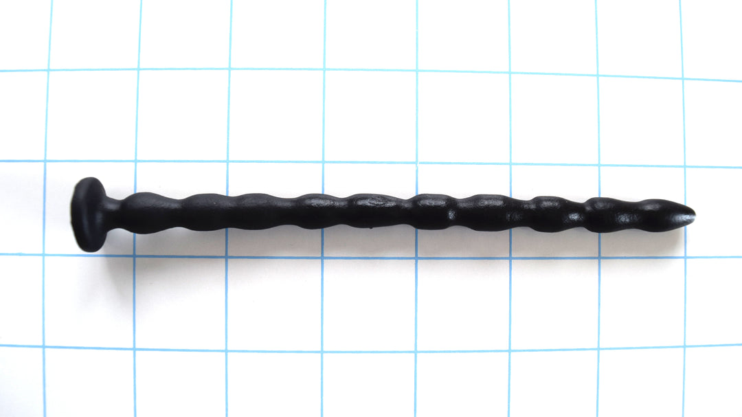SSND-MRB 8-10mm flexible multi-ribbed silicone urethral sound, featuring a gently tapered tip, 10 graduated ribs (8.4mm to 10mm), a 6.7mm retention valley, a flared base flange, and 6-inch insertable length, shown on a grid background.