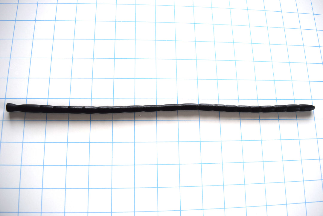 SSND-MRB20 flexible black silicone urethral sound shown horizontally on a grid background from Screenshot 2026-07-02 124255.jpg, displaying its 4.5mm entry tip, 20 distinct graduated rib segments ranging from 7.5mm to 8.5mm, shifting relief valleys, and a 9mm flared safety base flange