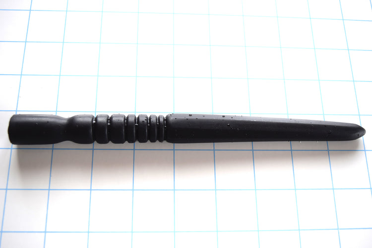 SSND-OCTA-SIDE expert black silicone urethral sound shown horizontally on a white background with 1"x1" blue grid squares from Screenshot 2026-07-02 154901.jpg, highlighting its 120mm octagonal faceted shaft peaking at 18mm, 45mm fast ribbed section, and 18.5mm multi-tier retention base.