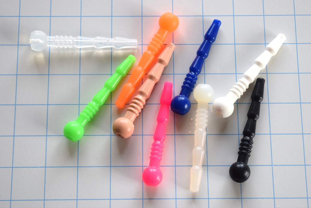 SSND-Quad Rib short silicone catheter plug showing tapered tip, alternating swells, quad ribs, and ball flange in multiple colors.