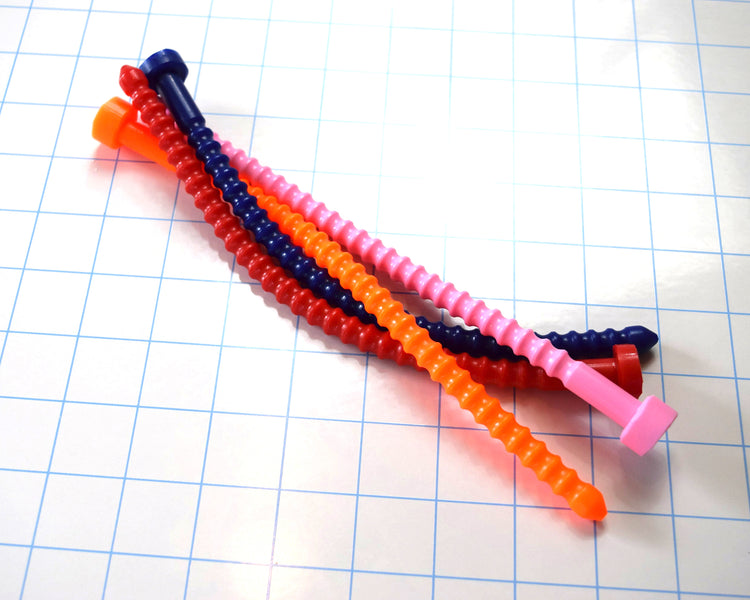 Group of red, blue, orange, and pink 6mm ribbed silicone sound probes stacked together on a grid surface.