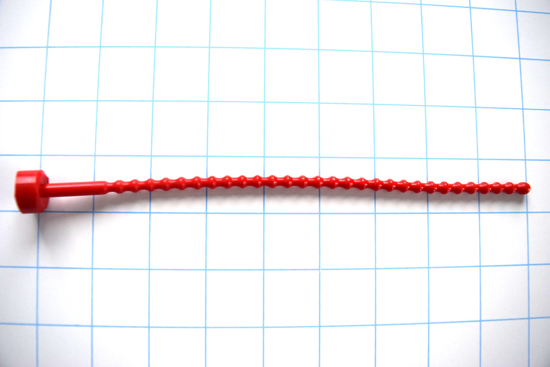 SSND-RIB-6mm soft flexible silicone urethral stretching insert featuring 29 ribbed contours along an 8.5-inch polished shaft, a rounded entry tip, and an integrated safety base flange on a grid background.