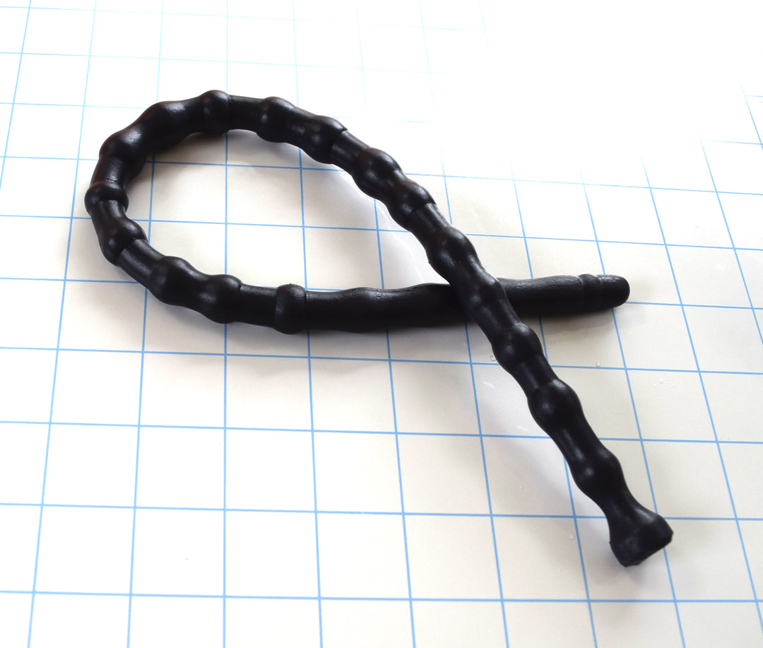 SSND-RNDMBALL 10-13 advanced black silicone urethral sound shown looped on a white background with 1"x1" blue grid squares from Screenshot 2026-07-02 152626.jpg, showcasing its flexible 22-node shifting column, 13.3mm maximum peak segments, and flared safety base flange