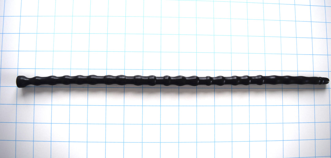 SSND-RNDMBALL 11-14mm extra-large black silicone urethral sound shown horizontally on a white background with 1"x1" blue grid squares from Screenshot 2026-07-02 141616.jpg, showcasing its 22 massive multi-size nodes peaking at 14mm, 16.5-inch insertable length, and integrated safety base flange