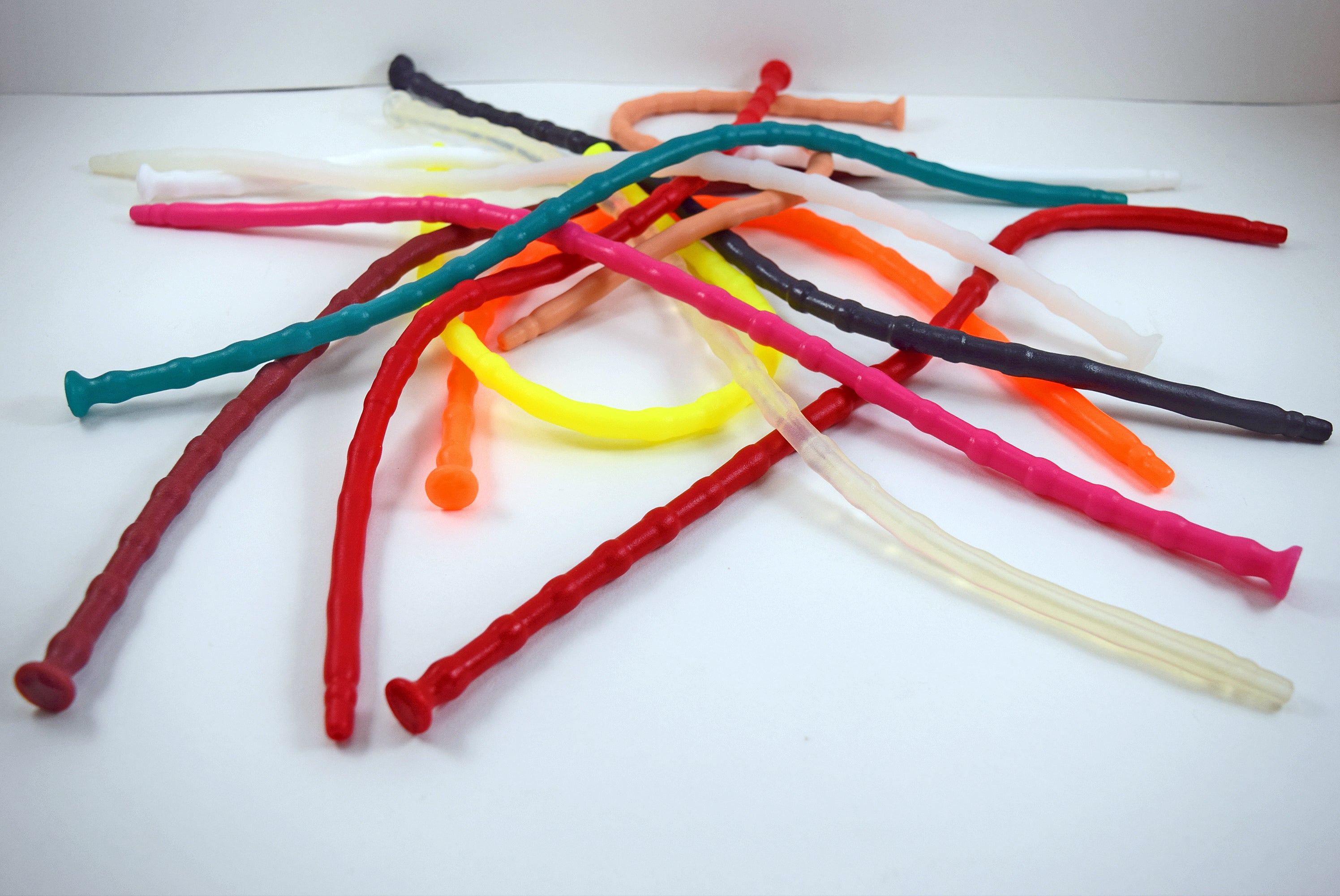 A large pile of SSND-RNDMBALL 7-10mm ribbed silicone sounds displayed in an assortment of vibrant colors including teal, red, yellow, pink, orange, and clear.