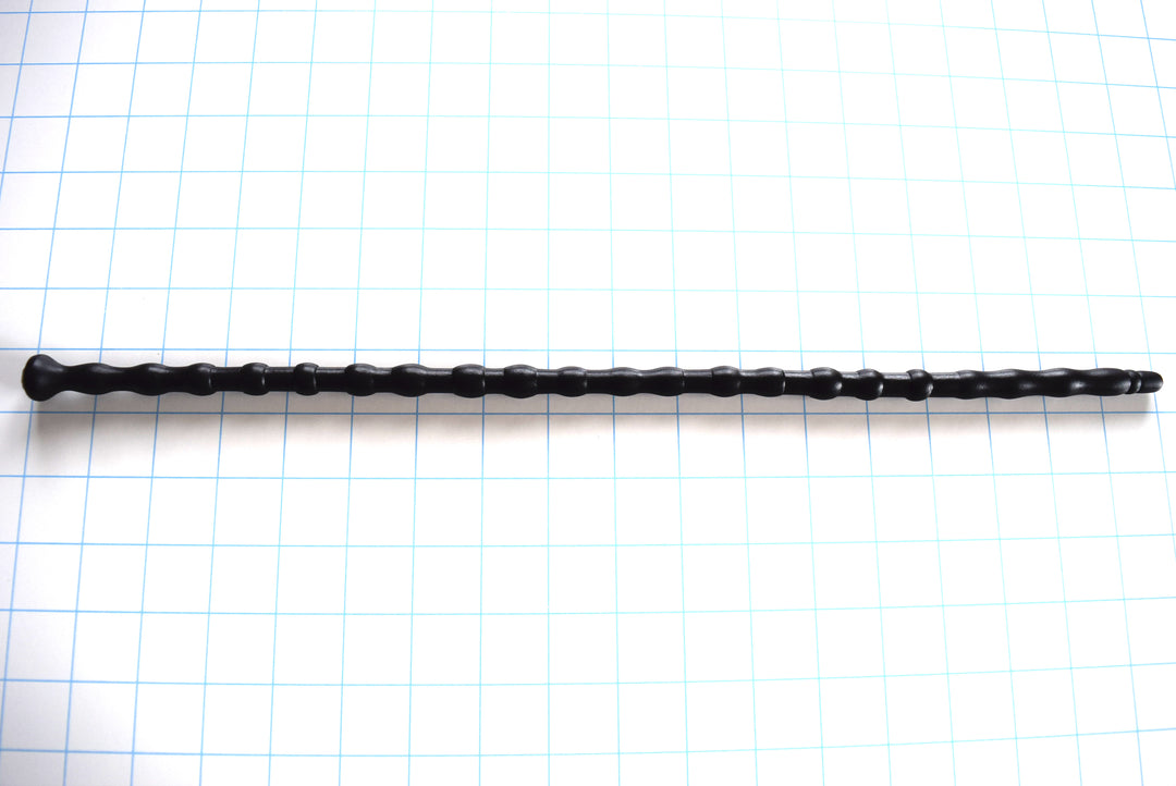 SSND-RNDMBALL 9-12.5 extra-long black silicone urethral sound shown horizontally on a white background with 1"x1" blue grid squares from Screenshot 2026-07-02 140857.jpg, highlighting its 22 distinct spherical and tapered nodes peaking at 12.7mm, 16.5-inch insertable length, and flat safety base flange