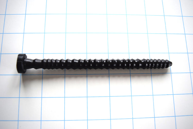 SSND-ShrpRIB 1 medium-diameter black silicone urethral sound shown horizontally on a white background with 1"x1" blue grid squares from Screenshot 2026-07-02 135417.jpg, highlighting its polished entry tip, continuous array of sharp 11.5mm ridges, and flat safety base flange.
