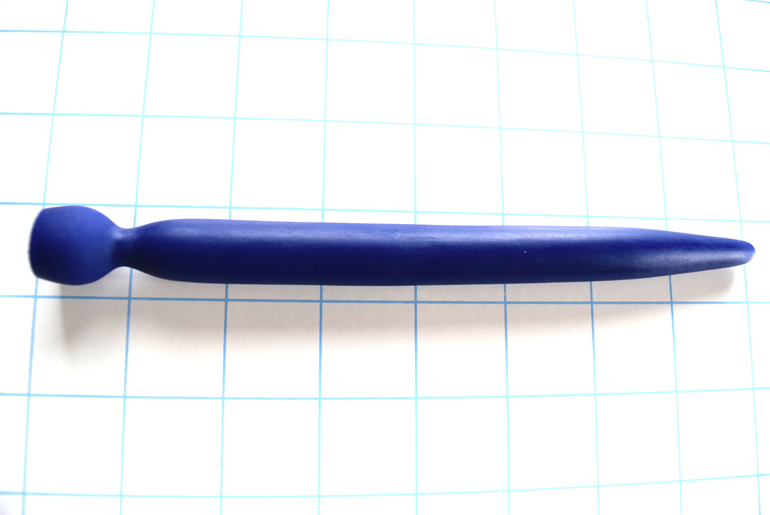 SSND-SMTPR-13.5mm gradual taper silicone urethral sound shown in blue on a grid background, displaying its elongated 7mm to 12mm tip, 13.5mm maximum diameter shaft, 8mm retention valley, and 16.5mm safety base flange