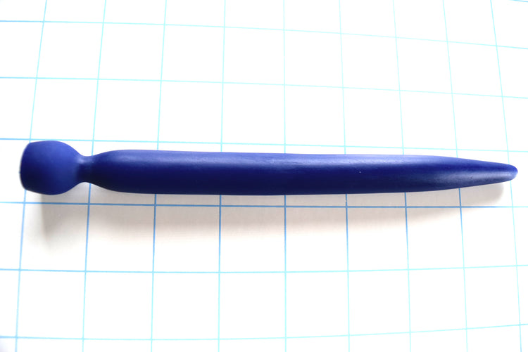 SSND-SMTPR-13.5mm gradual taper silicone urethral sound shown in blue on a grid background, displaying its elongated 7mm to 12mm tip, 13.5mm maximum diameter shaft, 8mm retention valley, and 16.5mm safety base flange
