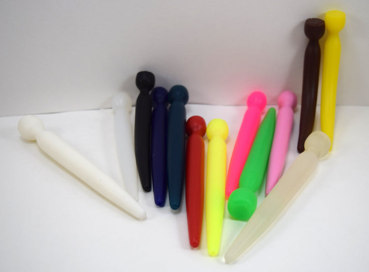 A colorful collection of tapered silicone urethral sounds shown standing upright and lying down on a white surface.