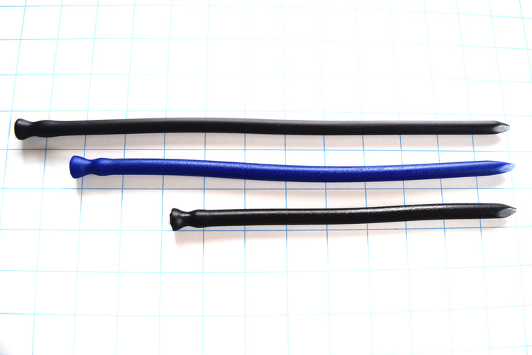 Black and blue spike-tip silicone urethral sounds in three lengths resting horizontally on a blue grid background.