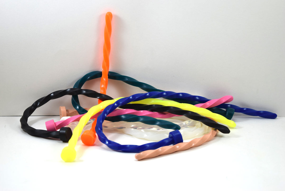 A colorful pile of thick spiral-twisted silicone urethral sounds shown in assorted colors on a white background.