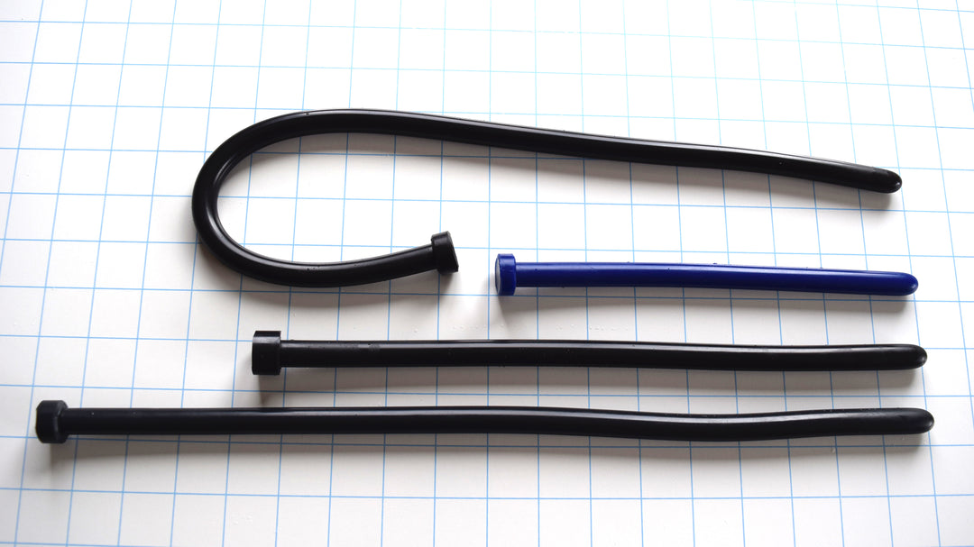 SSND-The Rod 12.5mm diameter smooth silicone urethral sound displayed in 12, 16, and 20 inch insertable length options in black and blue on a blue grid background, demonstrating its uniform cylindrical shaft and highly flexible profile