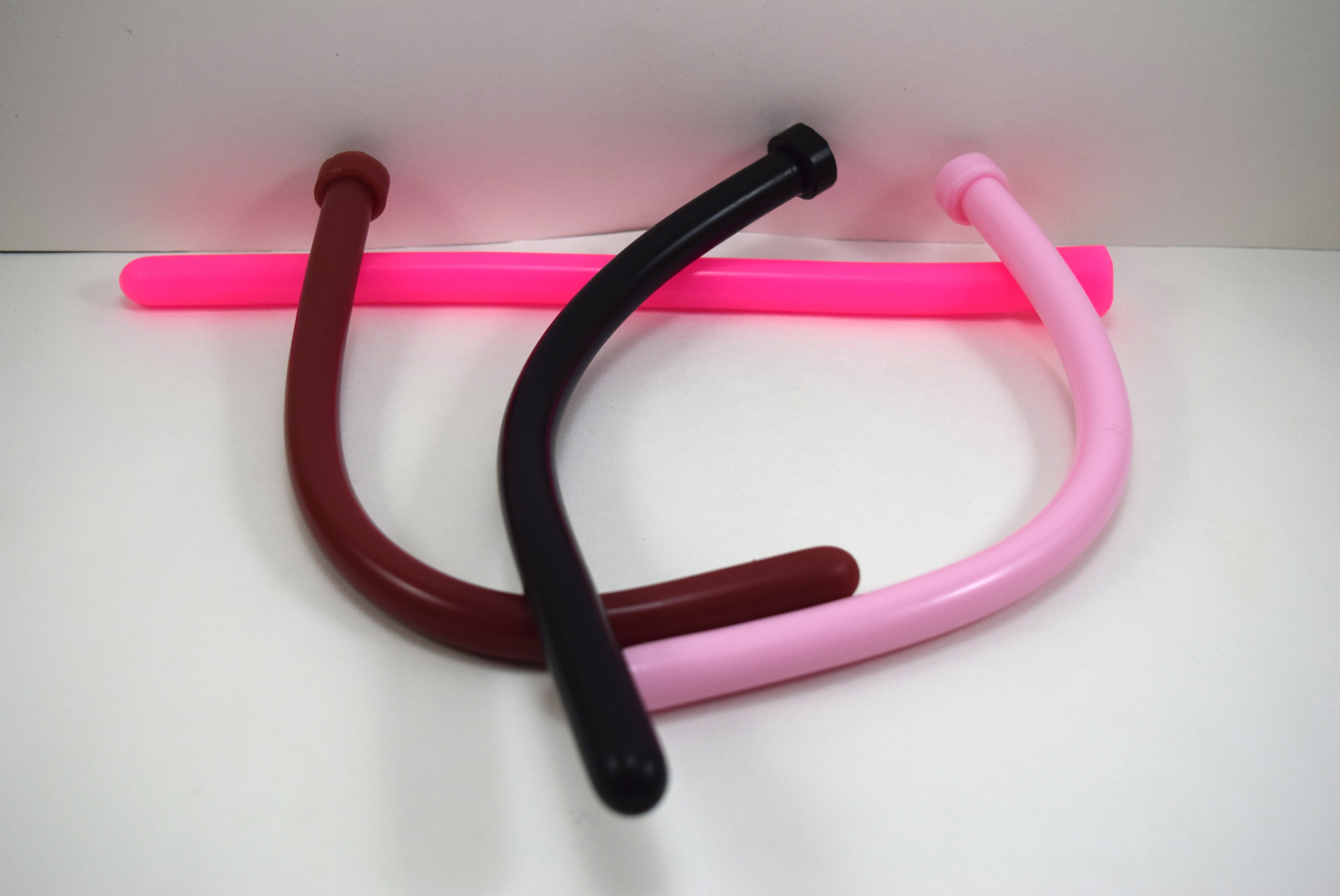 Four 14mm SSND silicone sounds called The Rod arranged together, showing flexible maroon, black, light pink, and bright neon pink options.