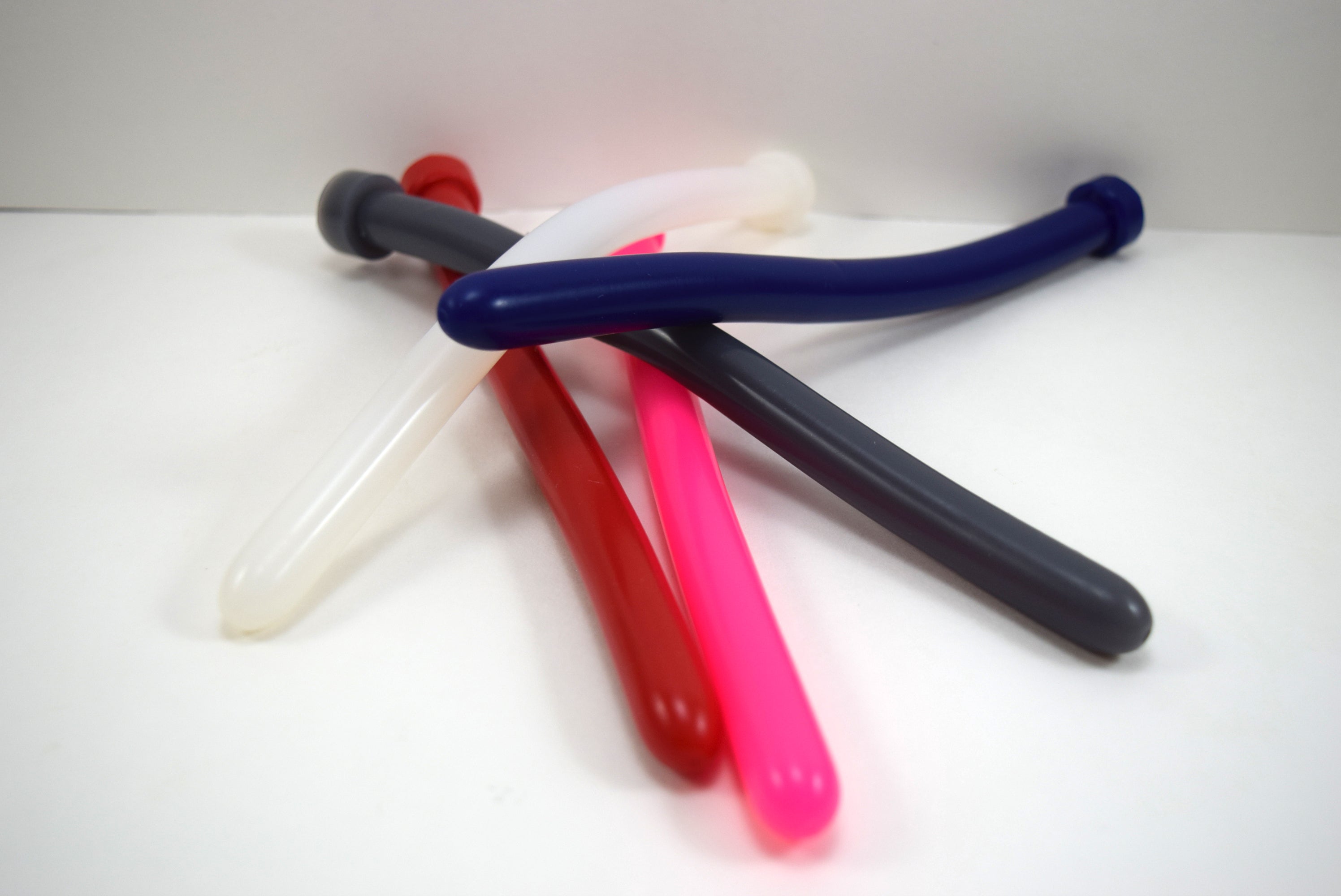 A pile of SSND 14mm silicone sounds called The Rod shown in multiple colors including navy blue, pink, red, translucent white, and charcoal gray.