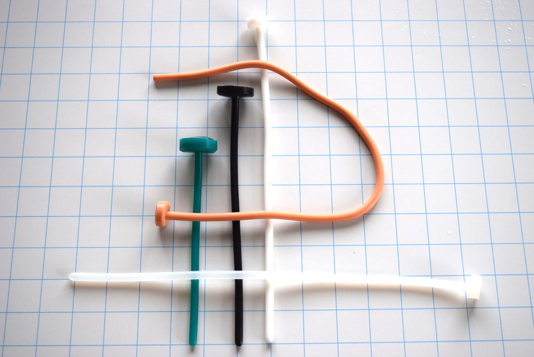 SSND-The Rod 6mm silicone sounding rods shown vertically and horizontally against a white background with a 1"x1" blue grid, featuring colorful flexible silicone shafts with flat safety flange bases.